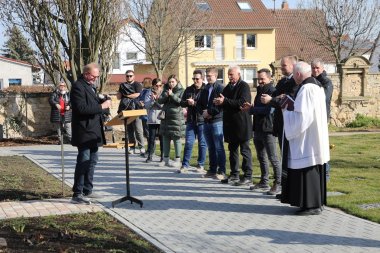 Foto Einweihungsfeier Memoriam Garten Ortsbürgermeister Baumann hält eine Rede vor Besuchern