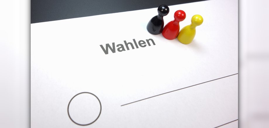 Teaserbild zu Wahlen auf dem steht "Wahlen" ein Kreis eingezeichnet  ist mit einer Linie und schwarz rot gelbe figuren